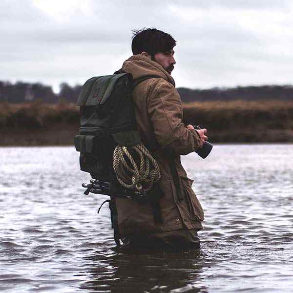 Nicolas Bruno standing in the water holding a camera during photosession